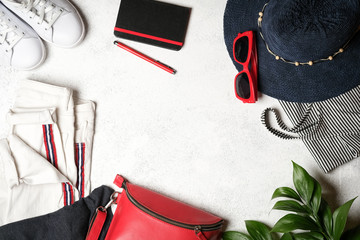 Set of women's accessories for summer holidays with a retro camera on a light background top view...