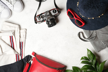 Set of women's accessories for summer holidays with a retro camera on a light background top view copy space.