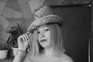 Portrait of a lady in a wicker hat, black-white retro photo.