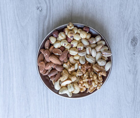 Healthy food. Nuts mix assortment on white grey table top view. Collection of different legumes for background image close up nuts, pistachios, almond, cashew nuts, peanut, walnut. image
