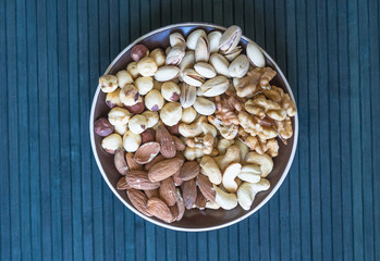 Healthy food. Nuts mix assortment on stone texture top view. Collection of different legumes for background image close up nuts, pistachios, almond, cashew nuts, peanut, walnut. image