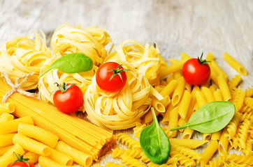 different pasta with tomatoes and spinach leaves