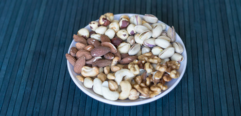 Healthy food. Nuts mix assortment on stone texture top view. Collection of different legumes for background image close up nuts, pistachios, almond, cashew nuts, peanut, walnut. image