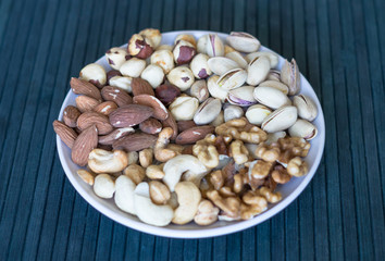 Healthy food. Nuts mix assortment on stone texture top view. Collection of different legumes for background image close up nuts, pistachios, almond, cashew nuts, peanut, walnut. image