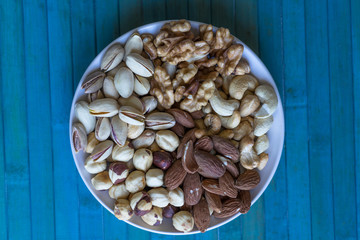 Healthy food. Nuts mix assortment on stone texture top view. Collection of different legumes for background image close up nuts, pistachios, almond, cashew nuts, peanut, walnut. image