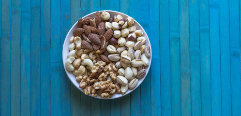 Healthy food. Nuts mix assortment on stone texture top view. Collection of different legumes for background image close up nuts, pistachios, almond, cashew nuts, peanut, walnut. image
