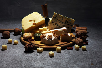 Cheese plate served with figs, various cheese on a platter on wood