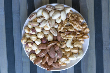 Healthy food. Nuts mix assortment on stone texture top view. Collection of different legumes for background image close up nuts, pistachios, almond, cashew nuts, peanut, walnut. image