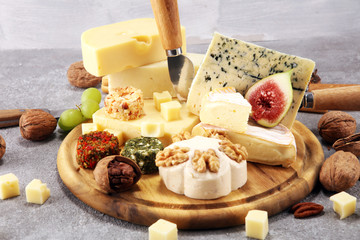 Cheese plate served with figs, various cheese on a platter on wood