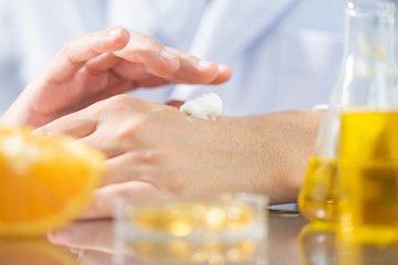 the scientist, dermatologist testing the organic natural cosmetic product in the laboratory, research and development beauty skincare concept, blank package, bottle, container, cream, serum, hand