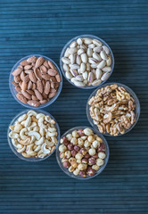 Healthy food. Nuts mix assortment on stone texture top view. Collection of different legumes for background image close up nuts, pistachios, almond, cashew nuts, peanut, walnut. image