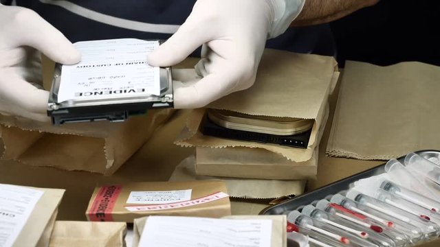 Police expert examines hard drive in search of evidence, conceptual image