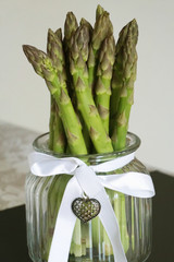Bunch of fresh asparagus officinalis plant upright in decorative jar