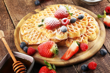 Waffle. Traditional belgian waffles with fresh fruit and powder sugar on wood