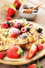 Waffle. Traditional belgian waffles with fresh fruit and powder sugar on wood