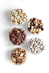 Healthy food. Nuts mix assortment on white grey table top view. Collection of different legumes for background image close up nuts, pistachios, almond, cashew nuts, peanut, walnut. image