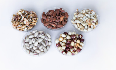 Healthy food. Nuts mix assortment on white grey table top view. Collection of different legumes for background image close up nuts, pistachios, almond, cashew nuts, peanut, walnut. image