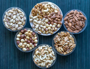 Healthy food. Nuts mix assortment on stone texture top view. Collection of different legumes for background image close up nuts, pistachios, almond, cashew nuts, peanut, walnut. image