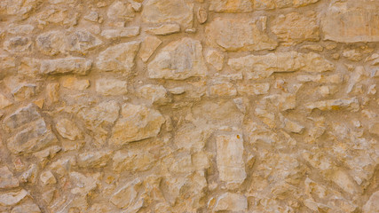 Background of old stone wall. The texture of the stone surface. Brickwork in the old European city. Pattern in retro style