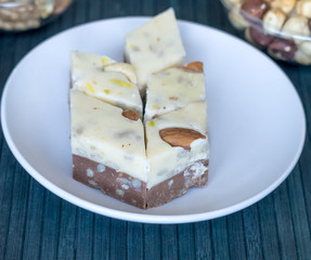 Oriental dessert halva with pistachio, almond, cashew nuts, peanut, walnut  on a  plate. Image. Healthy food. closeup of sweets  Machane Yehuda Market, Turkish Delight. Isolated on white background