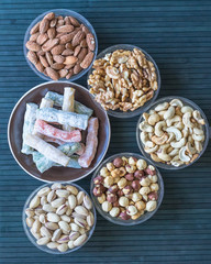 Traditional Turkish Delight. Oriental dessert halva on a  plate. Isolated on background. Eastern delicacy sweets. Healthy food. Nuts mix assortment. image close up nuts, pistachios, almond, cashew nut