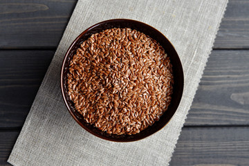 flax seeds in bowl on linen fabric background