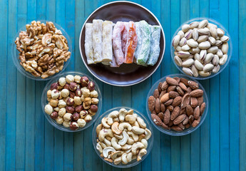  Oriental dessert halva with pistachio, almond, cashew nuts, peanut, walnut  on a  plate. Image. Healthy food. Nuts mix assortment. sweets, Turkish Delight. Isolated  background.. Eastern delicacy