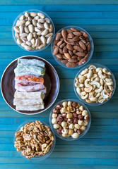Oriental dessert halva with pistachio, almond, cashew nuts, peanut, walnut  on a  plate. Image. Healthy food. Nuts mix assortment. sweets, Turkish Delight. Isolated  background.. Eastern delicacy