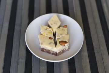  Oriental dessert halva with pistachio, almond, cashew nuts, peanut, walnut  on a  plate. Image. Healthy food. Nuts mix assortment. sweets, Turkish Delight. Isolated  background.. Eastern delicacy
