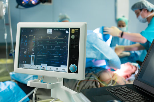 Electrocardiogram In Hospital Surgery Operating Emergency Room Showing Patient Heart Rate With Blur Team Of Surgeons Background