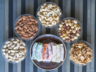  Oriental dessert halva with pistachio, almond, cashew nuts, peanut, walnut  on a  plate. Image. Healthy food. Nuts mix assortment. sweets, Turkish Delight. Isolated  background.. Eastern delicacy