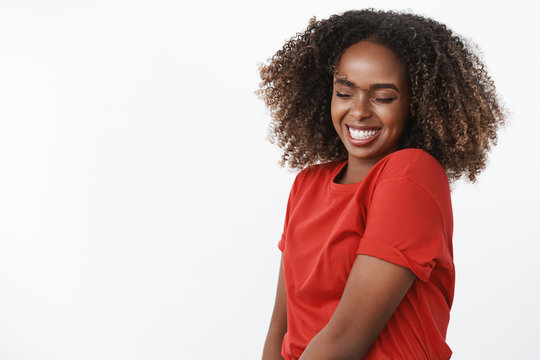 Dance like no one watching. Portrait of carefree and silly happy beautiful and sincere afrian-american young woman waving head and jumping with closed eyes and broad joyful smile over white wall