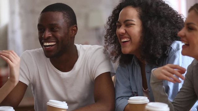 Happy multiracial young people friends talking laughing at group meeting