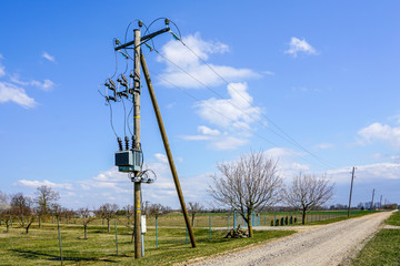 wooden power line pole with electric transformer in rural area