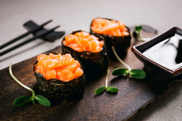 Seafood delicatessen salmon gunkan maki sushi rolls on wooden plate. Delicacy gourmet snacks. Luxury lifestyle, expensive food, restaurant menu