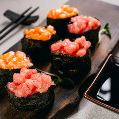 Seafood delicatessen gunkan maki sushi rolls on wooden plate. Different gourmet snacks. Luxury lifestyle, expensive food, restaurant menu