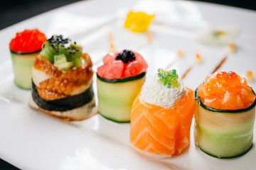 Seafood delicatessen sushi rolls on white plate. Different gourmet snacks. Luxury lifestyle, Japanese food art, expensive meals, restaurant menu