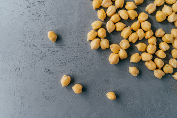 Healthy food concept. Protein nut seeds spill on grey background, copy space for text. Chickpea beans for tasty protein nutrition.