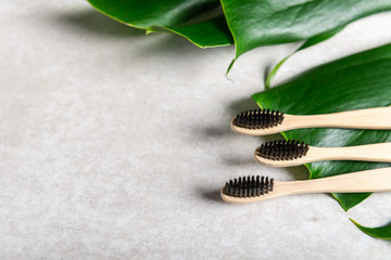 A family set of three wooden bamboo toothbrushes. Save the planet or NO plastic concept. Top view, flatlay, copy space