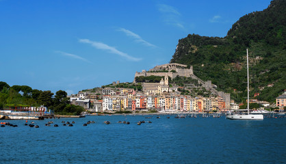 Fototapeta premium Portovenere town harbour, seafront, church and castle, visited and appreciated by tourists from around the world. Liguria, Italy, the Gulf of Poets.
