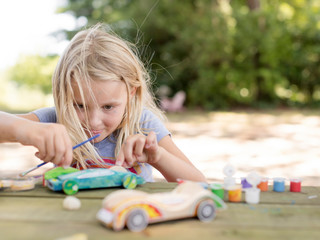 young girl building a toy car