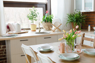 Modern design kitchen. Dining table setting with vase of flower