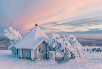 Small hexagonal cabin covered in snow