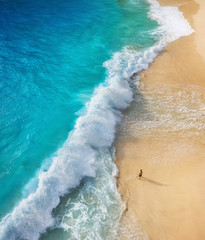 View of a man on the beach on Bali, Indonesia. Vacation and adventure. Top view from drone at beach, azure sea and relax man. Travel and relax - image