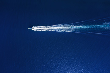 Yachts at the sea in Bali, Indonesia. Aerial view of luxury floating boat on transparent turquoise water at sunny day. Top view from drone. Seascape with motorboat in bay. Travel - image
