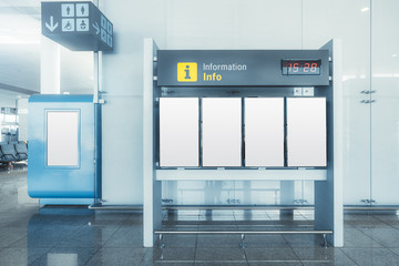 An Information or an arrival and departure board mock-up consisting of blank white vertical LCD screens in an airport terminal or a railway station depot with poster placeholder template on the left