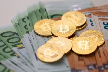 Euro banknotes and bitcoin coins used.