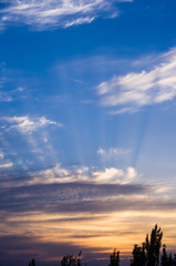 Landscape with dramatic light - beautiful golden sunset with saturated sky and clouds.