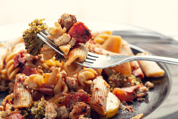 Pasta with herbs and vegetables on a fork. Mat filter.