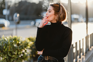 Pretty woman smoking on street